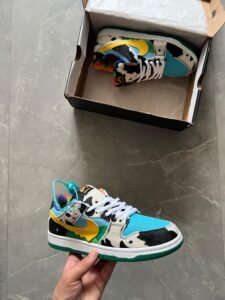 Multicolour low-top sneakers with black-and-white cow-print panels, turquoise toe sections, yellow accents, and a green outsole