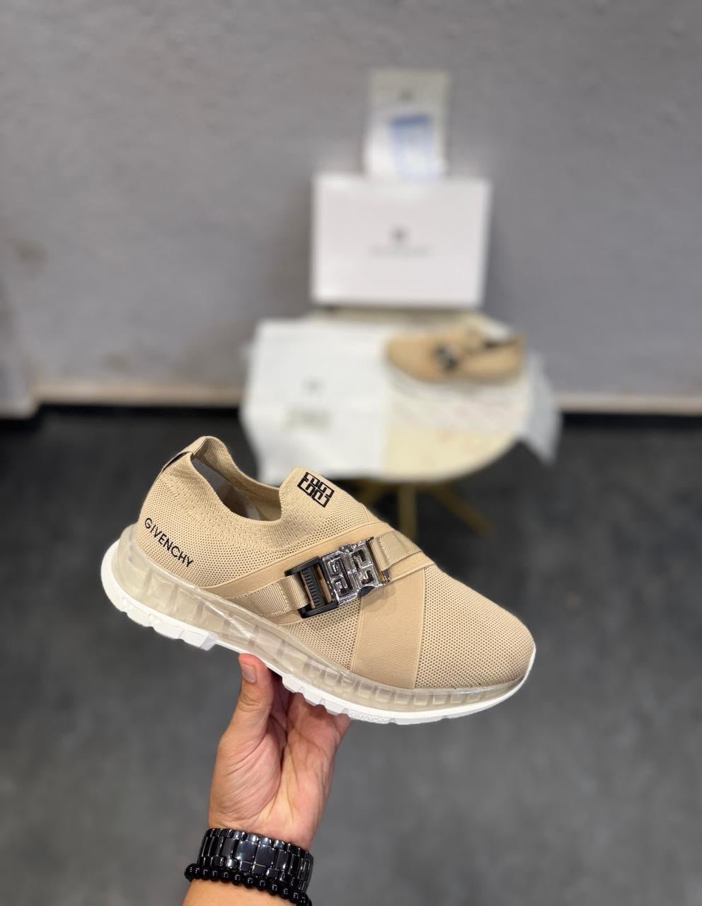 Beige Slip-On Sneakers – Metallic Buckle Luxury-Inspired Edition (3) Beige slip-on sneakers with a metallic silver-tone buckle, broad front strap, and sculpted white outsole