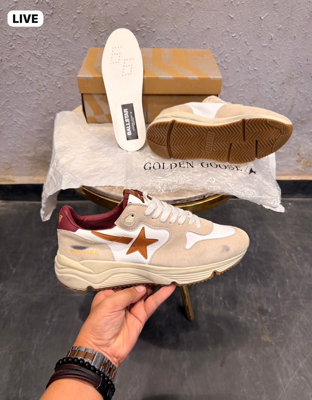 Beige and white low-top sneakers with brown star detailing, layered panels, and a chunky cream sole