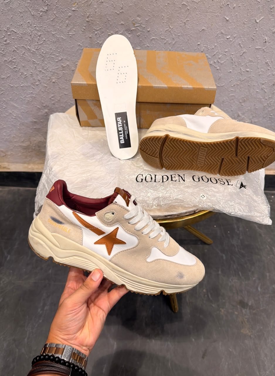 Beige and white low-top sneakers with brown star detailing, layered panels, and a chunky cream sole