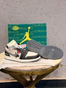 Black grey retro sneakers with contrasting panels, patterned laces, and a textured outsole
