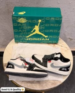 Black grey retro sneakers with contrasting panels, patterned laces, and a textured outsole