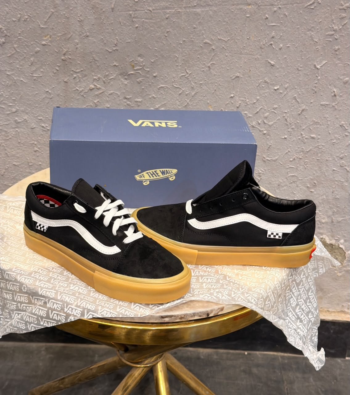 Black Low-Top Sneakers – Gum Sole Skate Style (1) Black low-top sneakers with white side detailing, white laces, checkerboard-inspired heel accents, and a gum-coloured sole