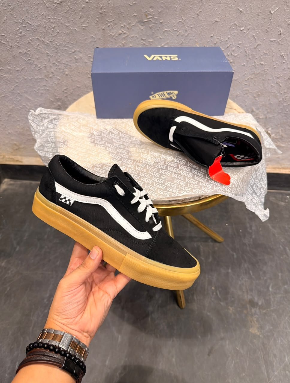 Black Low-Top Sneakers – Gum Sole Skate Style (2) Black low-top sneakers with white side detailing, white laces, checkerboard-inspired heel accents, and a gum-coloured sole