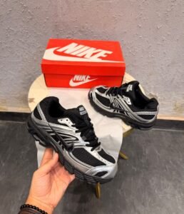 Black sneakers with metallic silver overlays, mesh-style panels, and a sculpted dark outsole
