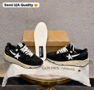 Black running-inspired sneakers with white star details, contrasting stitching, white laces, and a chunky cream sole