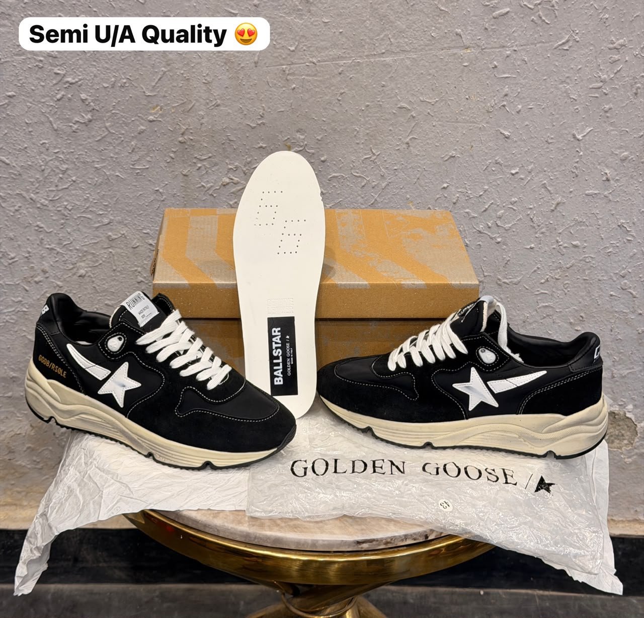 Black running-inspired sneakers with white star details, contrasting stitching, white laces, and a chunky cream sole