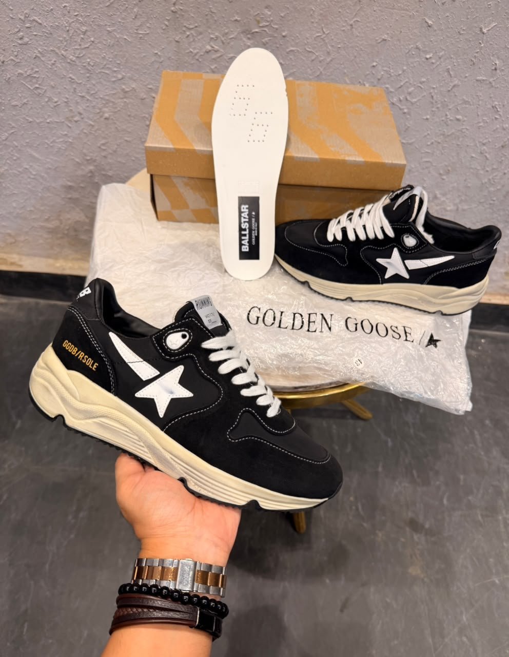 Black running-inspired sneakers with white star details, contrasting stitching, white laces, and a chunky cream sole