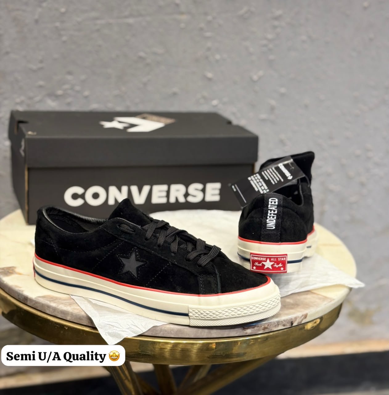 Black Suede Sneakers – Red Accent Retro Skate Edition (3) Black low-top sneakers with a textured suede-look upper, star-shaped side detail, cream sole, and red accent stripe