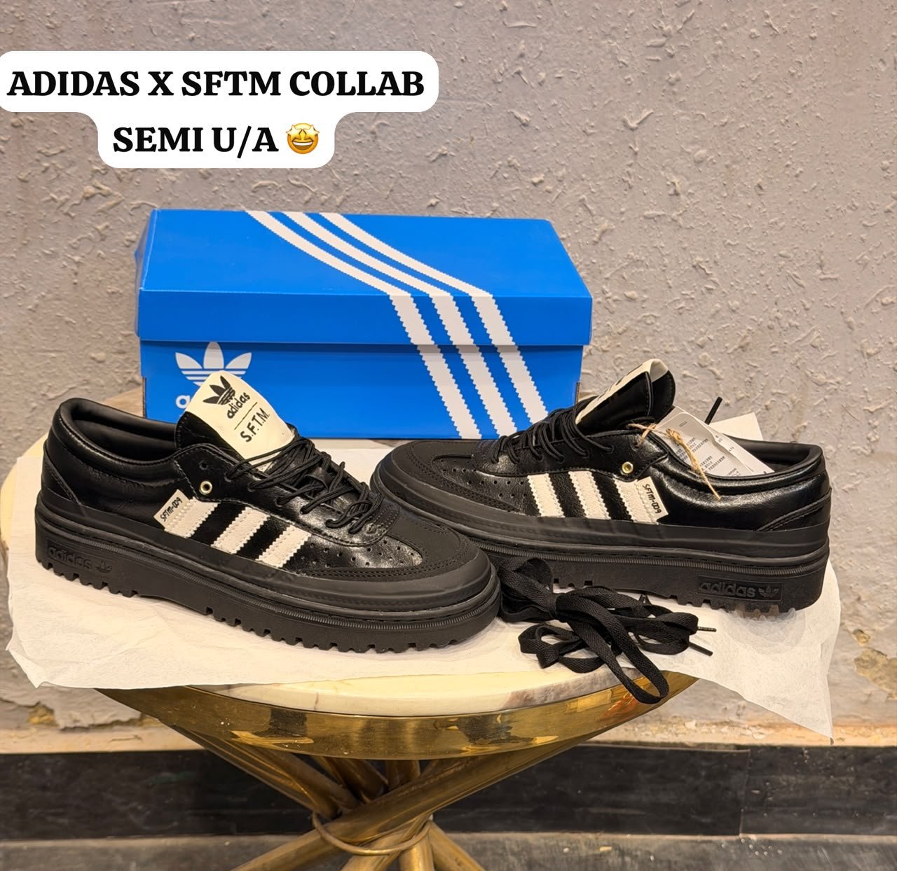 Black and white retro sneakers with contrasting side stripes, perforated panels, and chunky black soles