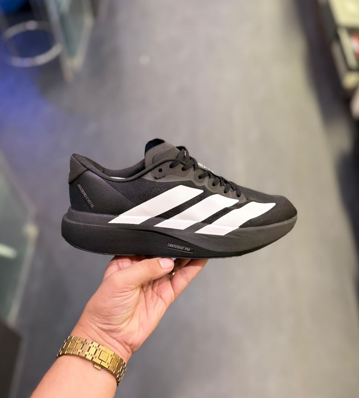 Black White Running Sneakers – Lightweight Performance-Inspired Edition (2) Black athletic-style sneakers with three white side stripes, black laces, and a sculpted black sole