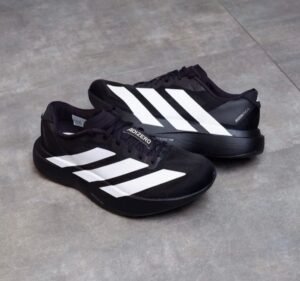 Black athletic-style sneakers with three white side stripes, black laces, and a sculpted black sole