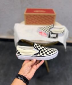 Black and cream checkerboard slip-on sneakers with a low-top silhouette and white sole