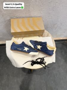 Blue denim-style sneakers with a cream star detail, lace-up fastening, and gum-style outsole