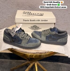 Blue and grey low-top sneakers with layered panels, perforated toe detailing, dark outsole, and decorative keychain