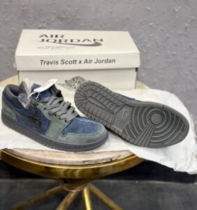 Blue and grey low-top sneakers with layered panels, perforated toe detailing, dark outsole, and decorative keychain