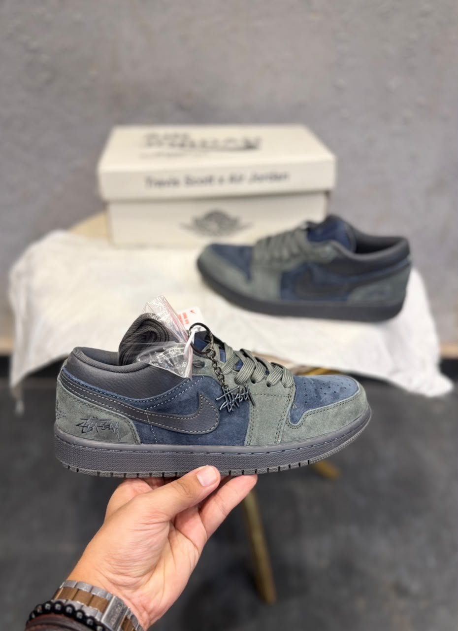 Blue and grey low-top sneakers with layered panels, perforated toe detailing, dark outsole, and decorative keychain