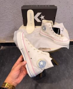 Celestial white high-top sneakers with pink trim, blue ankle emblem, and yellow outsole