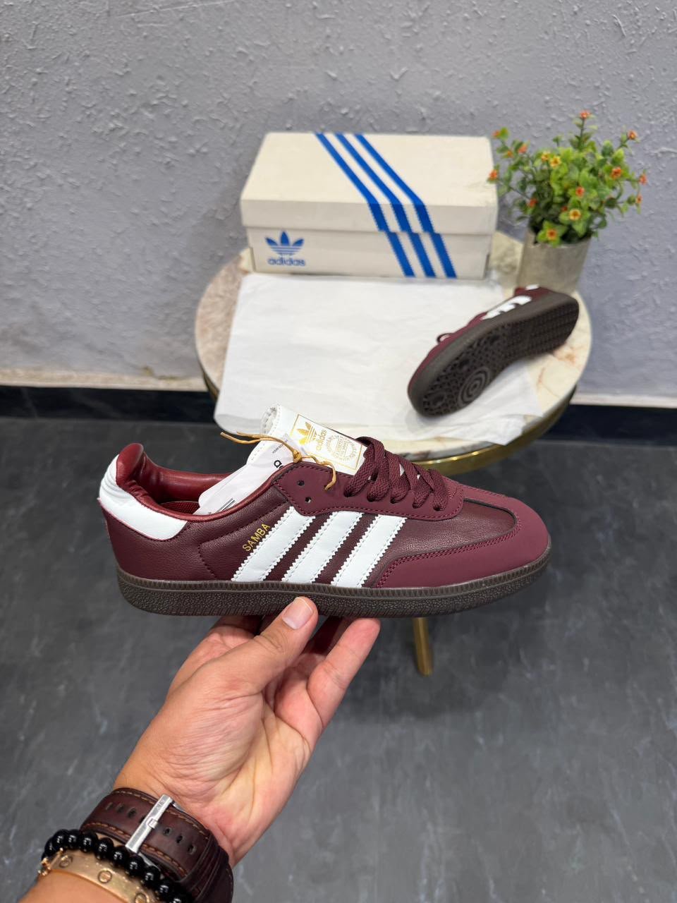 Cherry burgundy low-top sneakers with white side stripes, matching burgundy laces, and a dark brown patterned outsole