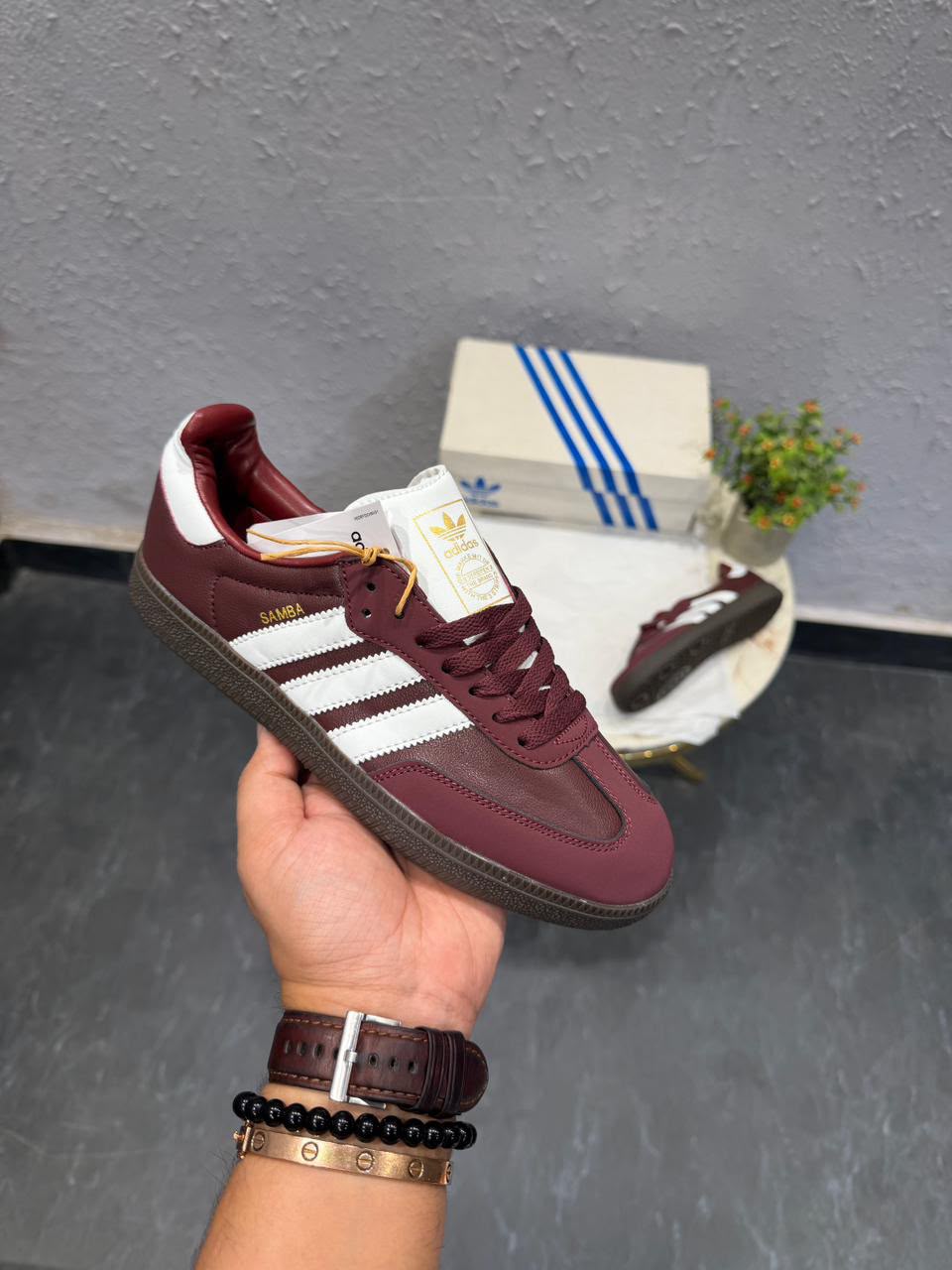 Cherry burgundy low-top sneakers with white side stripes, matching burgundy laces, and a dark brown patterned outsole