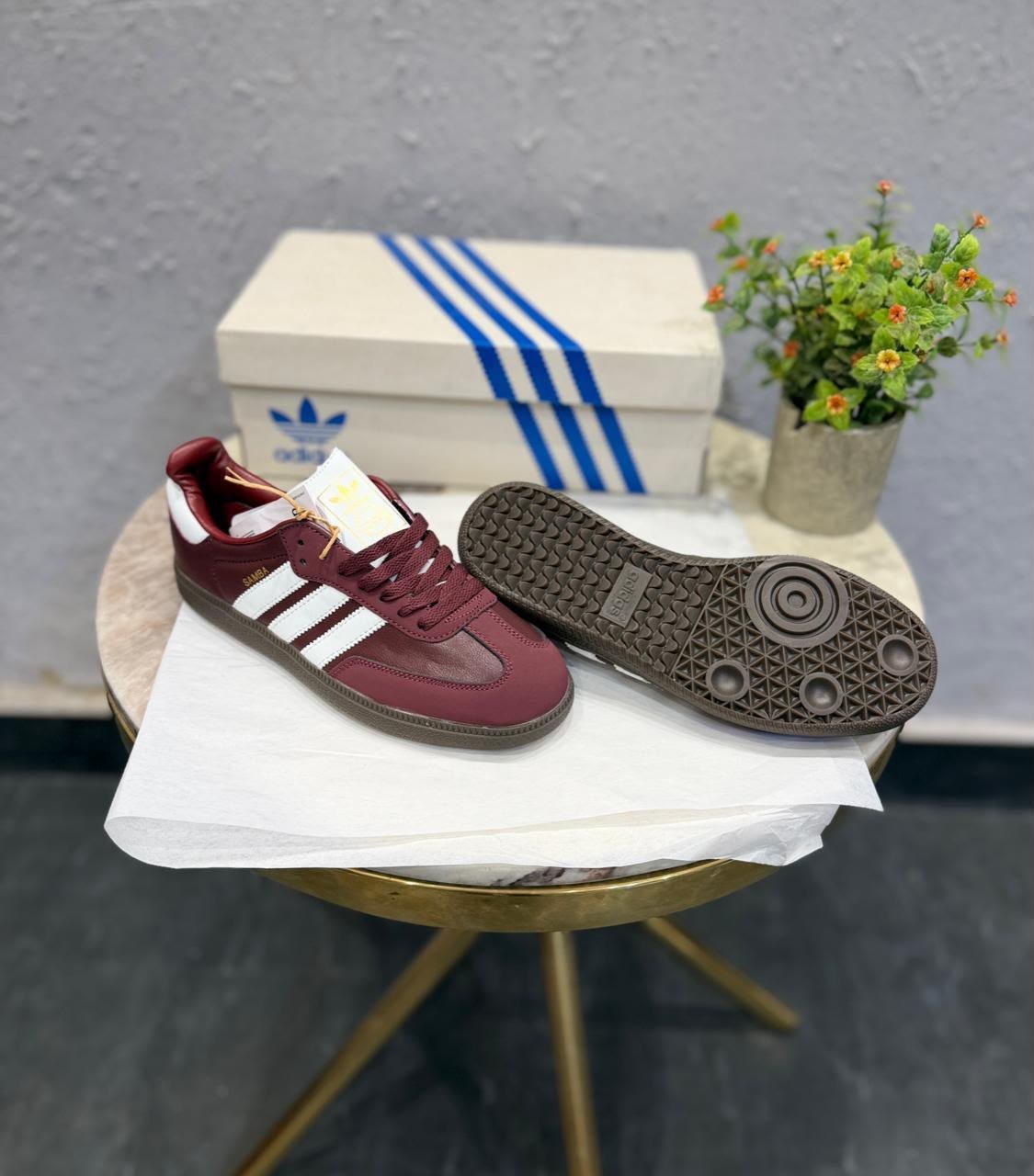Cherry burgundy low-top sneakers with white side stripes, matching burgundy laces, and a dark brown patterned outsole