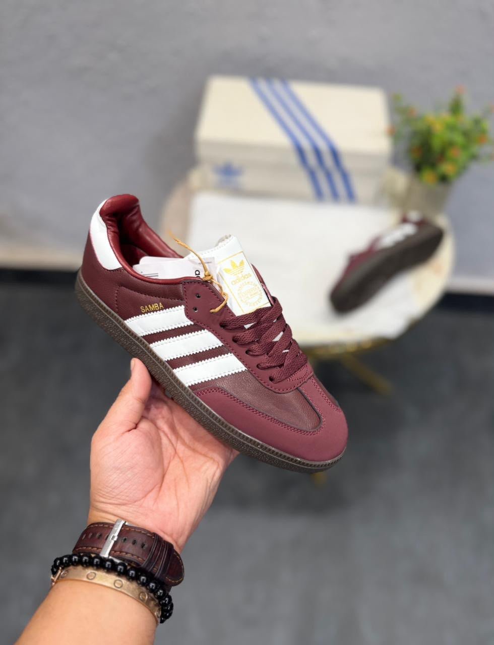 Cherry burgundy low-top sneakers with white side stripes, matching burgundy laces, and a dark brown patterned outsole