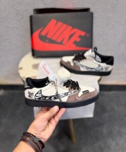 Cream and brown low top sneakers with layered overlays, black laces, patterned side detailing, and a black textured outsole