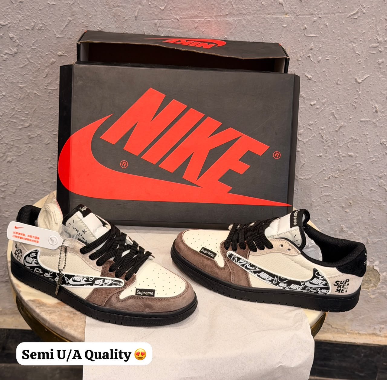 Cream and brown low top sneakers with layered overlays, black laces, patterned side detailing, and a black textured outsole