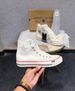 Cream high-top sneakers with red midsole piping, dark brown outsole, star-shaped side detail, and extra white laces