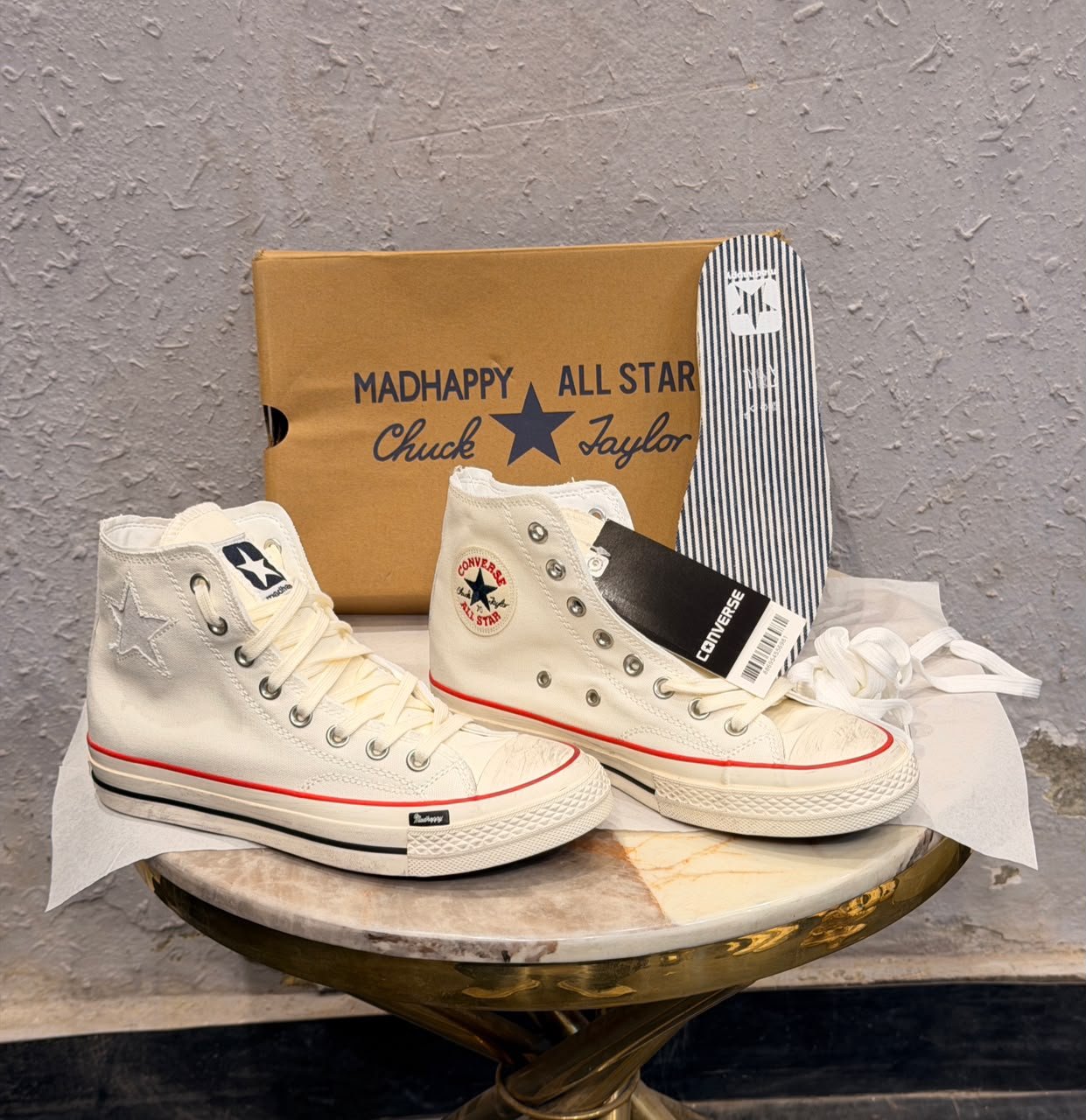 Cream high-top sneakers with red midsole piping, dark brown outsole, star-shaped side detail, and extra white laces