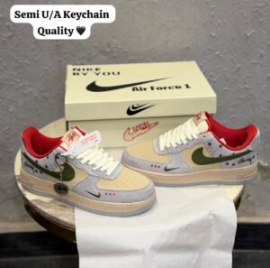 Grey low-top sneakers with olive-green accents, red lining, cream toe panels, decorative star graphics, and a grey circular-patterned outsole