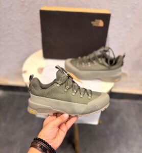 Khaki green outdoor-style sneakers with a grid-textured upper, reinforced-looking toe panel, and chunky taupe tread outsole