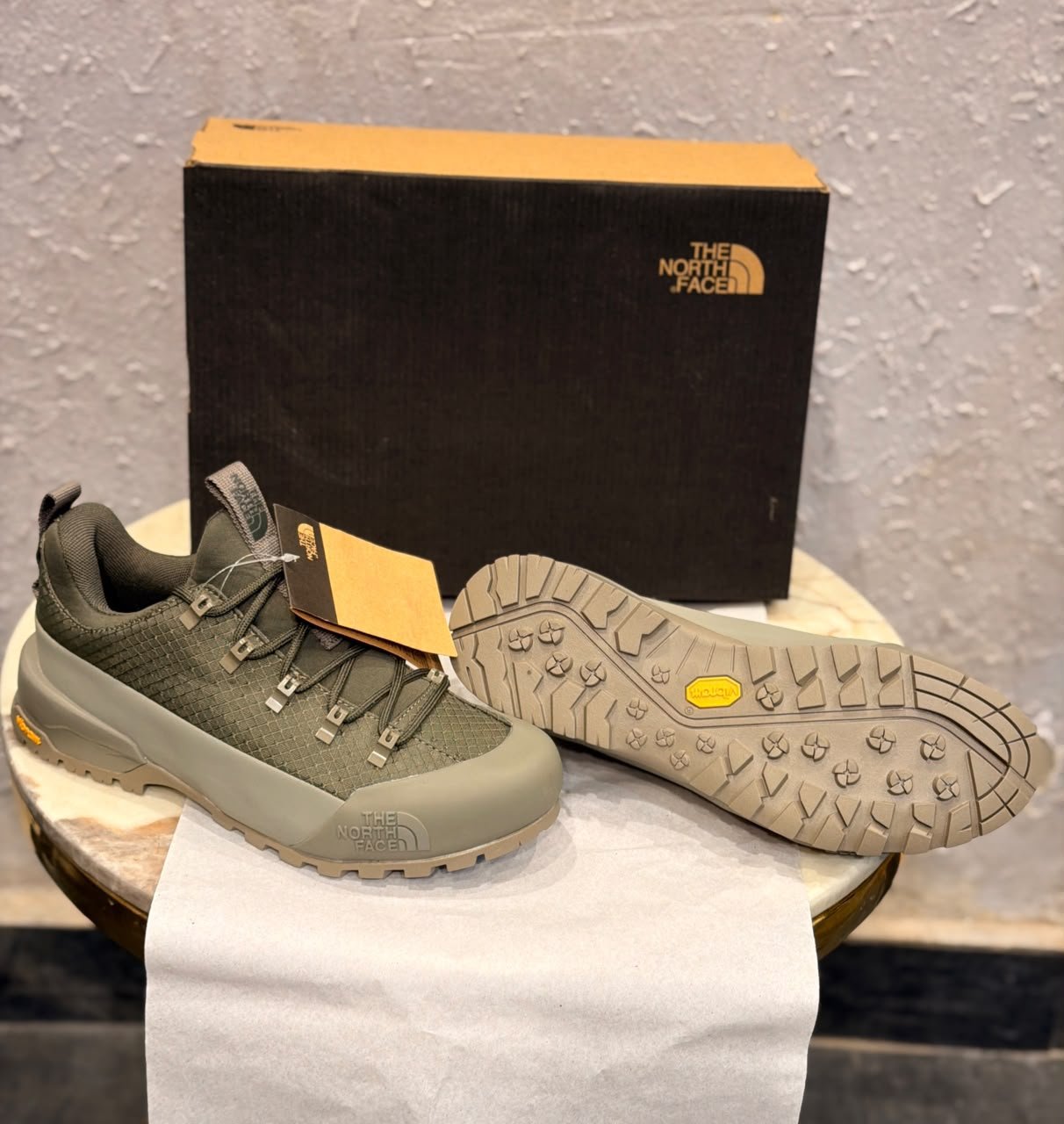 Khaki green outdoor-style sneakers with a grid-textured upper, reinforced-looking toe panel, and chunky taupe tread outsole