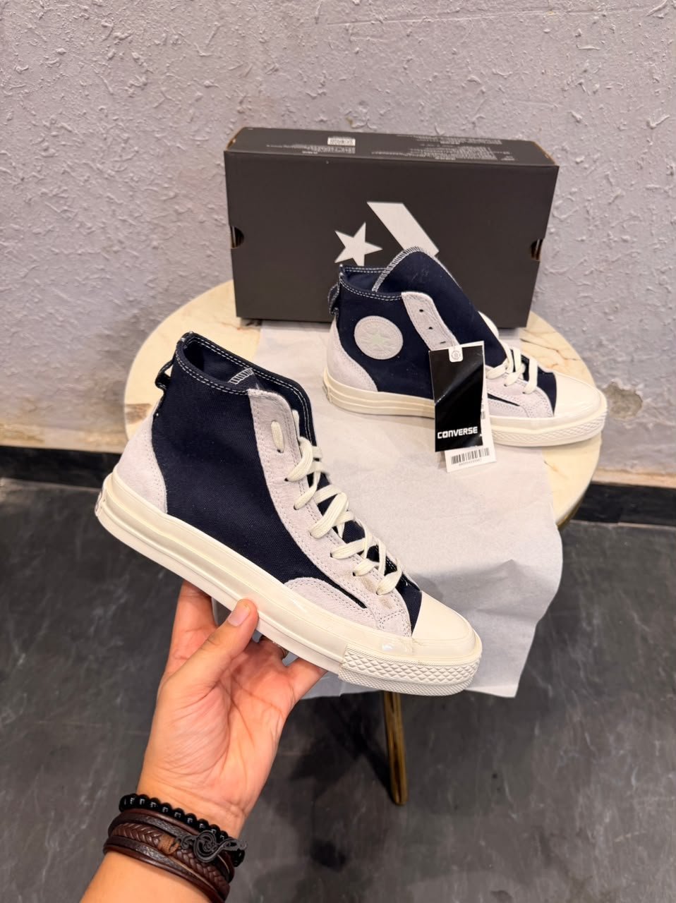 Obsidian navy high top sneakers with light grey overlays, cream laces, contrast stitching, and an off-white sole