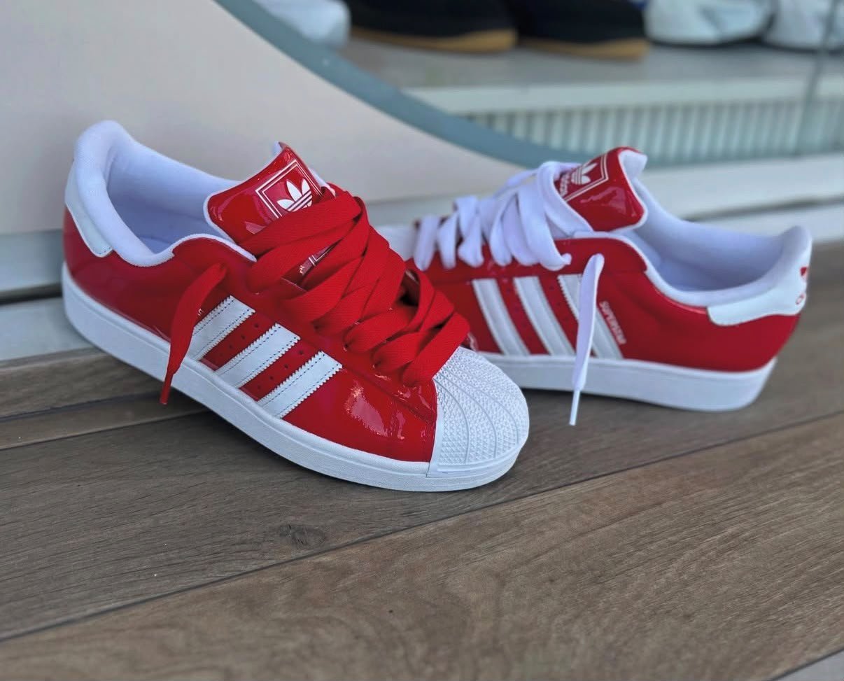 Red White Retro Sneakers – Classic Shell-Toe Streetwear Edition (3) Red and white low-top sneakers with contrasting white side stripes, matching laces, and a textured shell-shaped toe cap