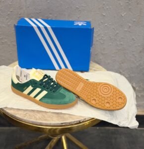 Green retro low-top sneakers with cream stripes, dark green laces, and a gum-colored sole