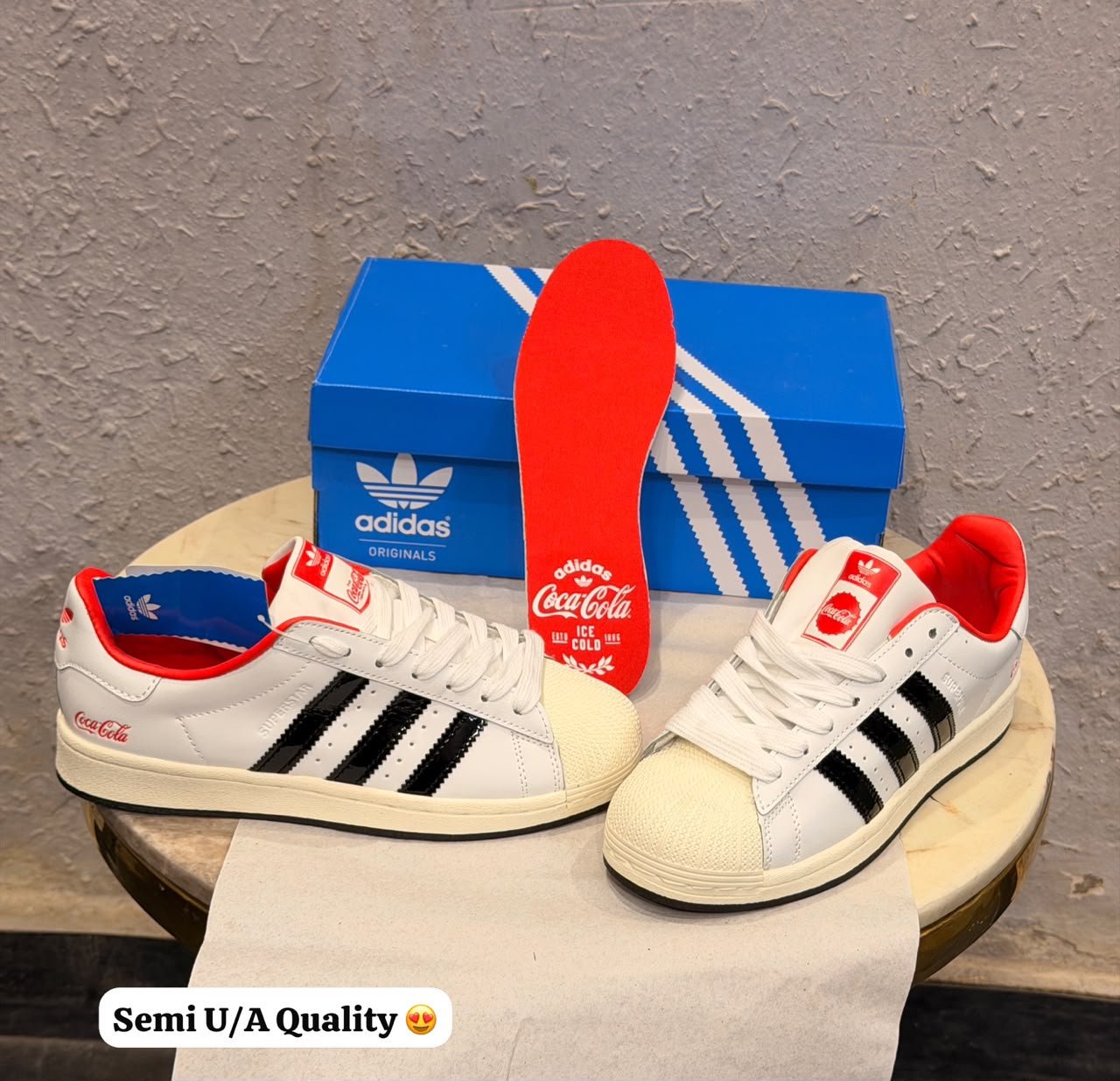 White and black low-top sneakers with red collar trim, blue lining, cream-toned sole, and beverage-inspired decorative detailing