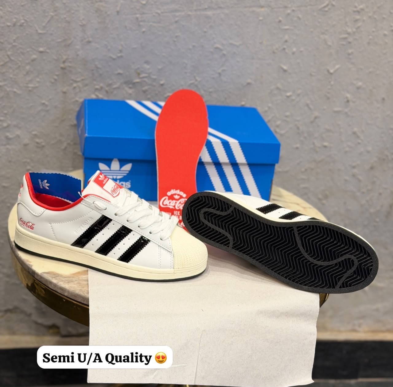 White and black low-top sneakers with red collar trim, blue lining, cream-toned sole, and beverage-inspired decorative detailing