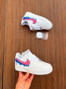 White custom low-top sneakers featuring colourful drip-art graphics in pink, blue, yellow, and purple