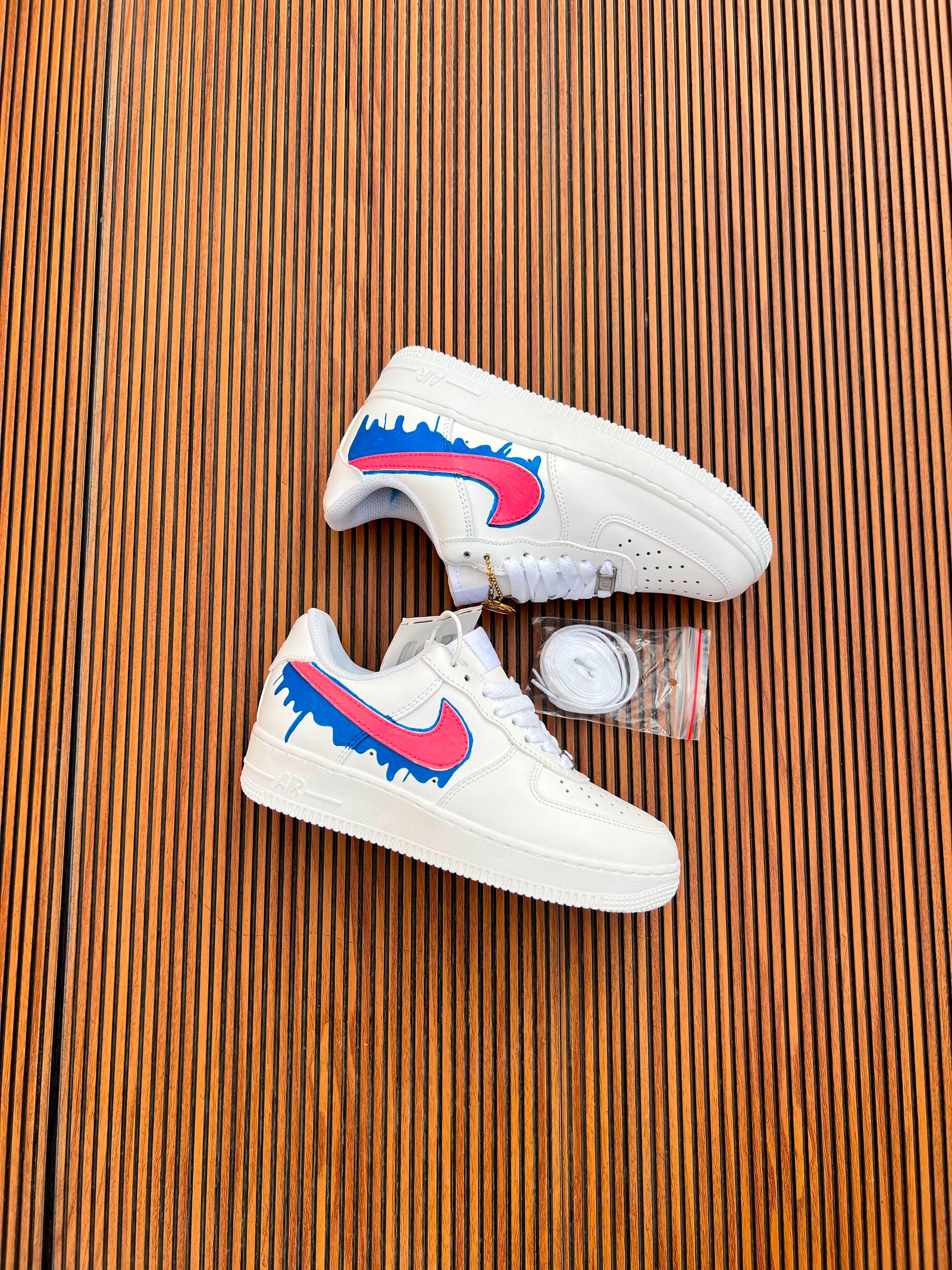 White Custom Sneakers – Multicolour Drip Art Edition (10) White custom low-top sneakers featuring colourful drip-art graphics in pink, blue, yellow, and purple