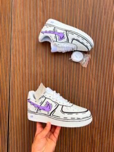 White custom low-top sneakers featuring colourful drip-art graphics in pink, blue, yellow, and purple