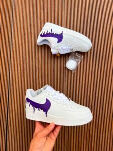 White custom low-top sneakers featuring colourful drip-art graphics in pink, blue, yellow, and purple