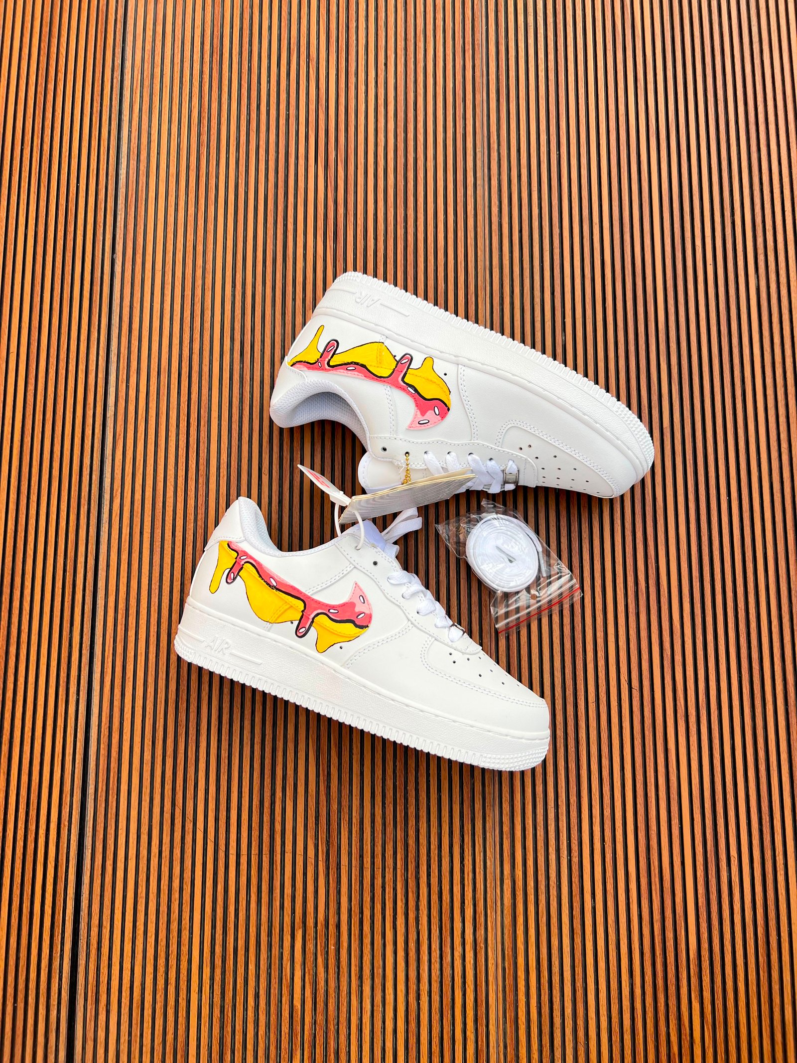 White Custom Sneakers – Multicolour Drip Art Edition (5) White custom low-top sneakers featuring colourful drip-art graphics in pink, blue, yellow, and purple