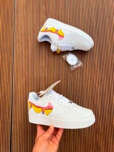 White custom low-top sneakers featuring colourful drip-art graphics in pink, blue, yellow, and purple
