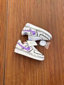 White custom low-top sneakers featuring colourful drip-art graphics in pink, blue, yellow, and purple