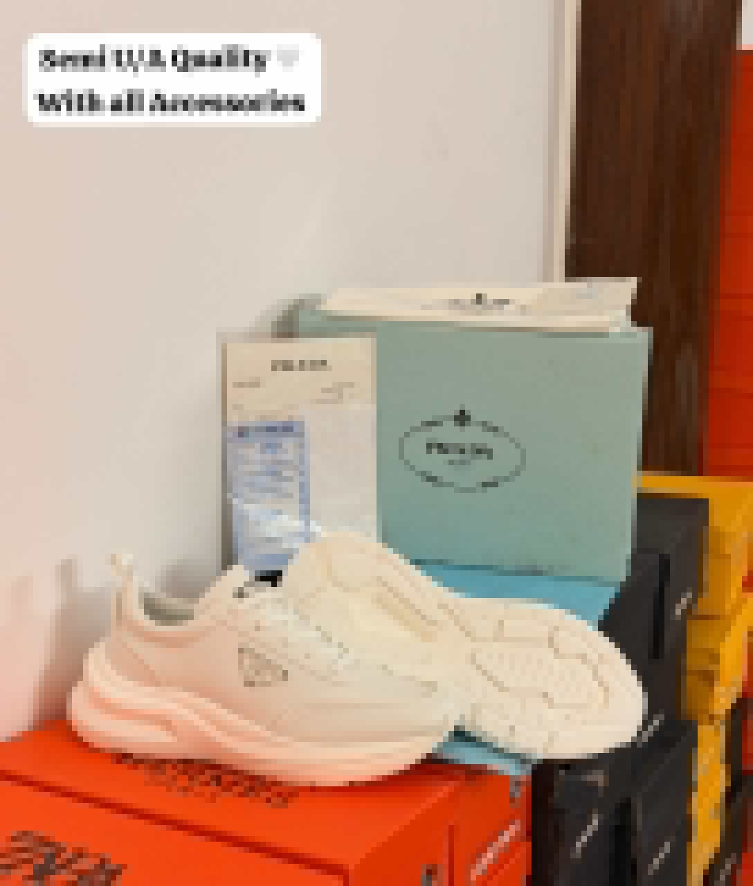 White minimalist low-top sneakers with a sculpted chunky sole, tonal panels, lace-up closure, and decorative side emblem