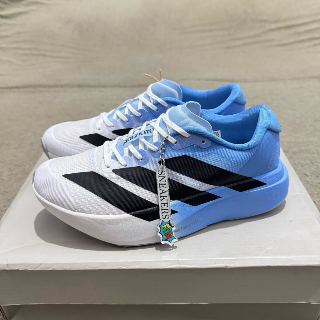 White and sky blue athletic-style sneakers with black side stripes, lace-up closure, and a sculpted white and blue sole