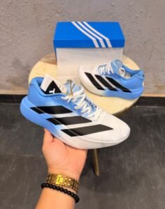 White and sky blue athletic-style sneakers with black side stripes, lace-up closure, and a sculpted white and blue sole